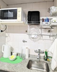 - un comptoir de cuisine avec évier et four micro-ondes dans l'établissement Florida Bedchamber, à Buenos Aires