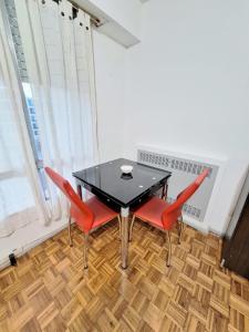 a dining room with a black table and red chairs at Florida Bedchamber in Buenos Aires