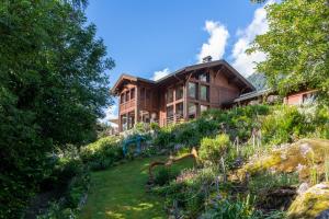 a house on a hill with a garden in front of it at Chalet Cinq Moutons in Orsières