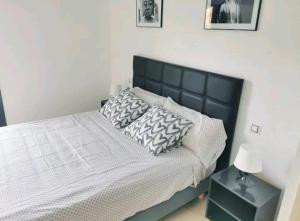 貝尼多姆的住宿－Mirador vistas panorámicas a Benidorm，一间卧室配有一张带黑色床头板和枕头的床。