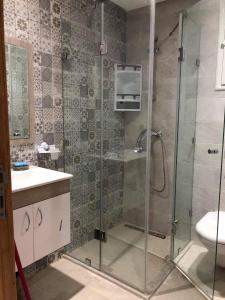 uma casa de banho com um chuveiro e um lavatório. em Appartement haut standing a sousse em La Corniche