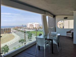 einen Balkon mit einem Glastisch und Meerblick in der Unterkunft luxury Plazza Sea view in Costa da Caparica