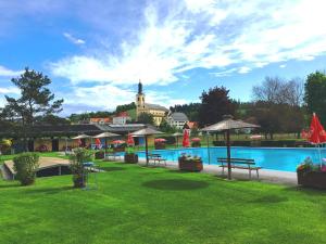 a resort with a swimming pool and a building at Ferienwohnung am Freibad in Leutschach