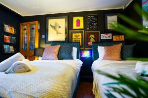 duas camas num quarto com fotografias na parede em Cheltenham 3 Bedroom Cottage-Neon Wonderland-Town Centre-Parking-Sleeps 6 