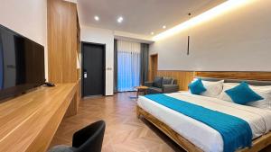 a bedroom with a bed and a chair and a television at No 33 Lodge in Dar es Salaam