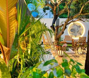 a garden with chairs and a tree and a deck at No.33 Lodge in Dar es Salaam
