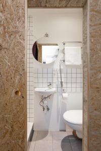 biała łazienka z toaletą i umywalką w obiekcie #stayhere - Stylish Studio Close to Old Town w Wilnie