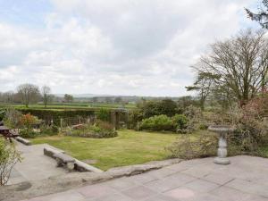 a garden with a bench and a bird bath at Green Haven Pembrokeshire in Pembrokeshire