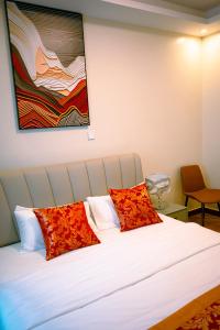 ein Schlafzimmer mit einem Bett mit zwei roten Kissen in der Unterkunft Noonluxuryliving in Kampala