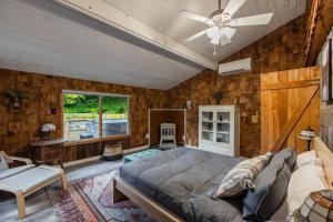um quarto com uma cama e uma ventoinha de tecto em Riverside Log Cabin w Hot Tub Fire Pit Huge Deck em Rileyville
