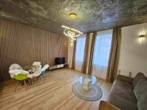a living room with a couch and a table and chairs at Lunar Luxury Appartment in Šiauliai