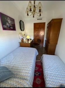 1 dormitorio con 2 camas y lámpara de araña en Casa Chalet Venta Ruizo, en Lorca