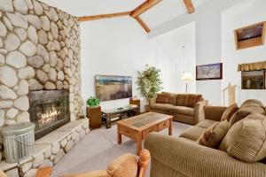 a living room with a large stone fireplace at Bear golf inn #1218 in Big Bear Lake