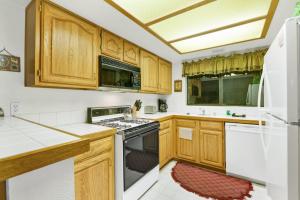 a kitchen with wooden cabinets and white appliances at Bear golf inn #1218 in Big Bear Lake