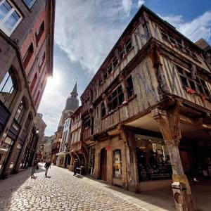 Un viejo edificio de madera en una calle adoquinada en cocooning centre Dinan, en Dinan