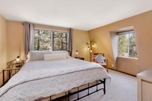 ein Schlafzimmer mit einem großen Bett und zwei Fenstern in der Unterkunft Pinewood inn #2093 in Big Bear Lake