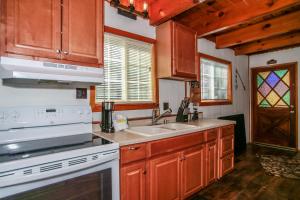 a kitchen with wooden cabinets and a white stove top oven at Palms to pines #1877 in Sugarloaf