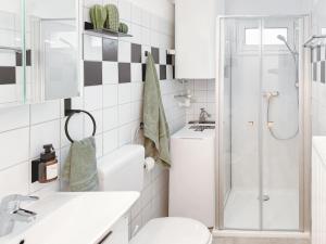 a white bathroom with a shower and a toilet at Central BOHO apartment 1 in Graz