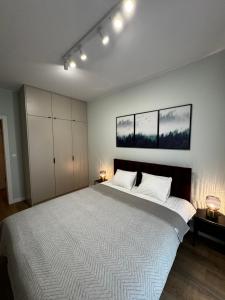 ein Schlafzimmer mit einem großen weißen Bett mit zwei Lampen in der Unterkunft Boho Apartments in Łódź