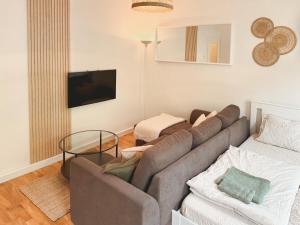 a living room with a couch and a tv at Central BOHO apartment 1 in Graz
