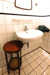 een badkamer met een witte wastafel en een kruk bij Ostoja Mików in Mików