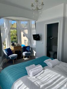 a bedroom with a large bed with a blue blanket at Bentley Lodge in Torquay
