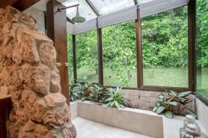 a bathroom with a stone wall and a window at Hacienda La Perezosa en Cerro Azul in Cerro Azul