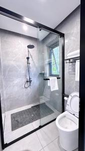 a bathroom with a glass shower with a toilet at No.33 Lodge in Dar es Salaam