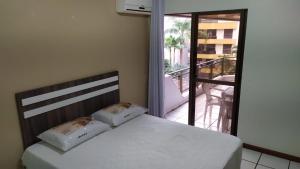 une chambre avec un lit et un balcon dans l'établissement Apartamento na quadra do mar, à Itapema 11 autres photos