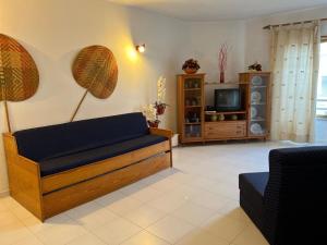 salon z kanapą i telewizorem w obiekcie Caparica ap vista mar w Costa de Caparica