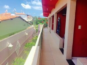 a walkway in a building with a red wall at Residencial La Puerta Del Sol in Porto De Galinhas