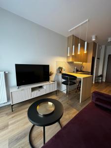 ein Wohnzimmer mit einem Sofa und einem Tisch in der Unterkunft Boho Apartments in Łódź