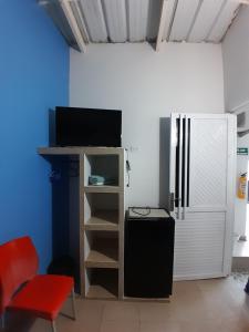 een kamer met een koelkast en een rode stoel bij Brisas del Mar Apto 1C in San Andrés