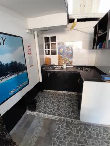 a kitchen with a black counter and a poster on the wall at Brisas del Mar Apto 1C in San Andrés