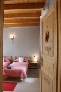 - une chambre avec 2 lits et une porte en bois dans l'établissement B&B La Casetta, à Induno Olona