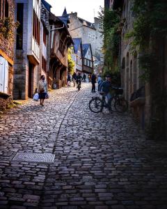 a cobblestone street with people riding bikes on it at cocooning centre Dinan in Dinan