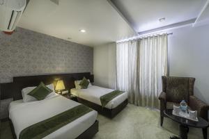 Postel nebo postele na pokoji v ubytování Hotel Raya Inn