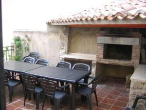 eine Terrasse mit einem Tisch, Stühlen und einem Kamin in der Unterkunft Apartamentos Miguel Angel in Beteta