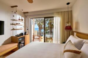 a bedroom with a bed and a view of the ocean at Alai Crete a Tribute Portfolio Resort in Stalida