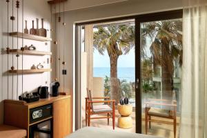 Alai Crete a Tribute Portfolio Resort في ستاليدا: غرفة نوم مع باب زجاجي منزلق مع إطلالة على المحيط