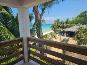 uma vista para a praia a partir da varanda de um resort em Roots Cafe Rooms em Negril