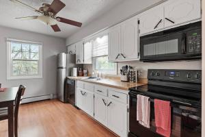 a kitchen with white cabinets and a black stove top oven at Tranquil 2BR Apt Mpls - 8075 Apt 3 in Minneapolis
