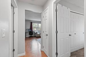 a hallway with white doors and a living room at Tranquil 2BR Apt Mpls - 8075 Apt 3 in Minneapolis