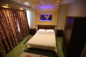 1 dormitorio pequeño con cama y cortinas en Hotel Ago en Berat