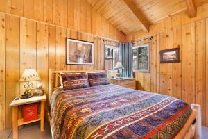 ein Schlafzimmer mit einem Bett in einer Holzhütte in der Unterkunft Oriole cottage #621 in Big Bear Lake