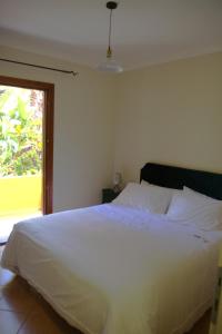 ein weißes Bett in einem Schlafzimmer mit einem Fenster in der Unterkunft NEST HOUSE - ESCLUSIVO APPARTAMENTO Marina di Olbia- MATER OLBIA - Beaches - close to the Airport - PRIVATE PARKING- Full comforts - in Olbia