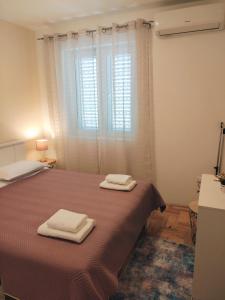 1 dormitorio con 1 cama con 2 toallas en Siesta Apartments, en Šibenik