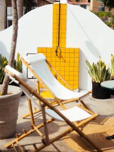 una silla amarilla y blanca sentada en un patio en Fausto, en Lima