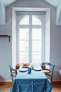 einen Tisch mit einem blauen Tischtuch und einem Fenster in der Unterkunft LE WOODY - 10min à pied de la Gare in Laval
