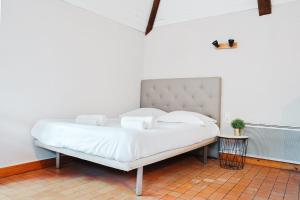 Bett mit weißer Bettwäsche und Kissen in einem Zimmer in der Unterkunft LE WOODY - 10min à pied de la Gare in Laval